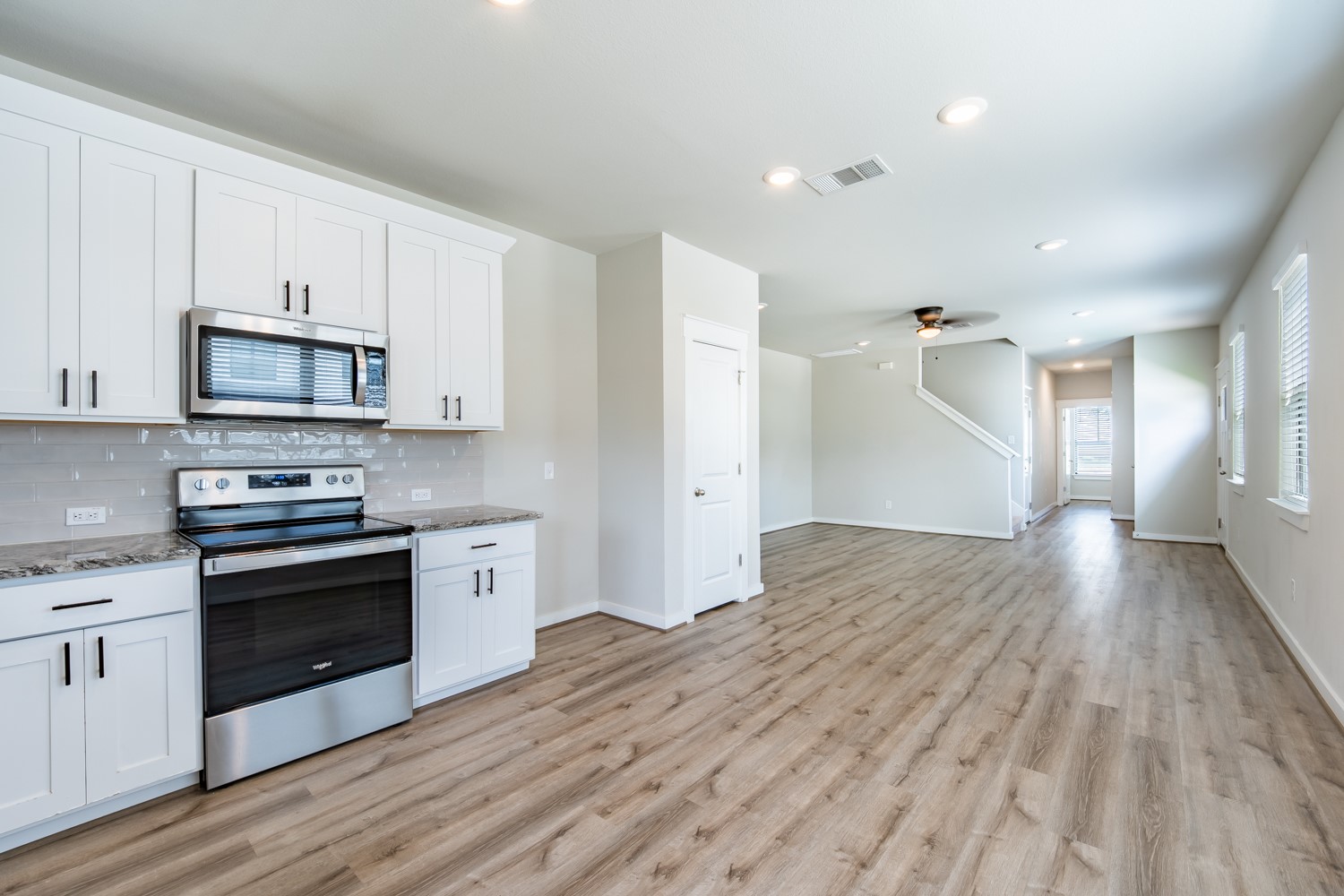 147 Waterside Road, Unit A Buda, TX 78610 - Photo 13 of 27 A well-lit interior showcases a contemporary kitchen with abundant cabinetry and a spacious open-concept living area.