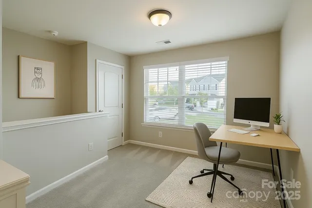 a view of a workspace with furniture and a window