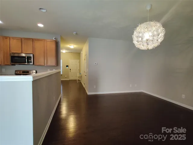 a kitchen with granite countertop a stove top oven a sink dishwasher and a microwave oven on the wooden floor