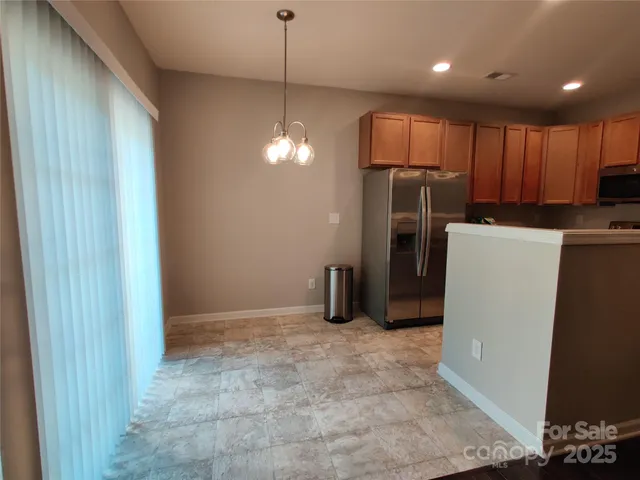 a view of a kitchen with a refrigerator wooden floor and a window