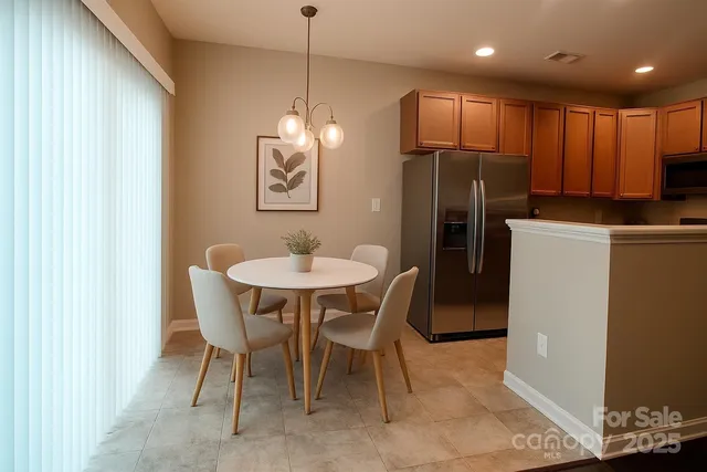 a kitchen with refrigerator and chairs