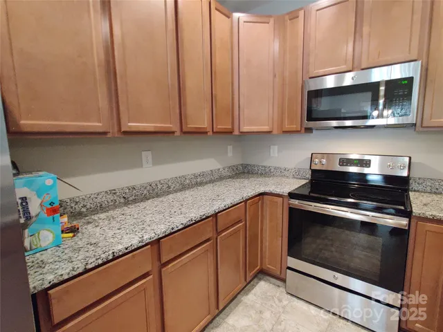 a kitchen with stainless steel appliances granite countertop a sink stove and microwave