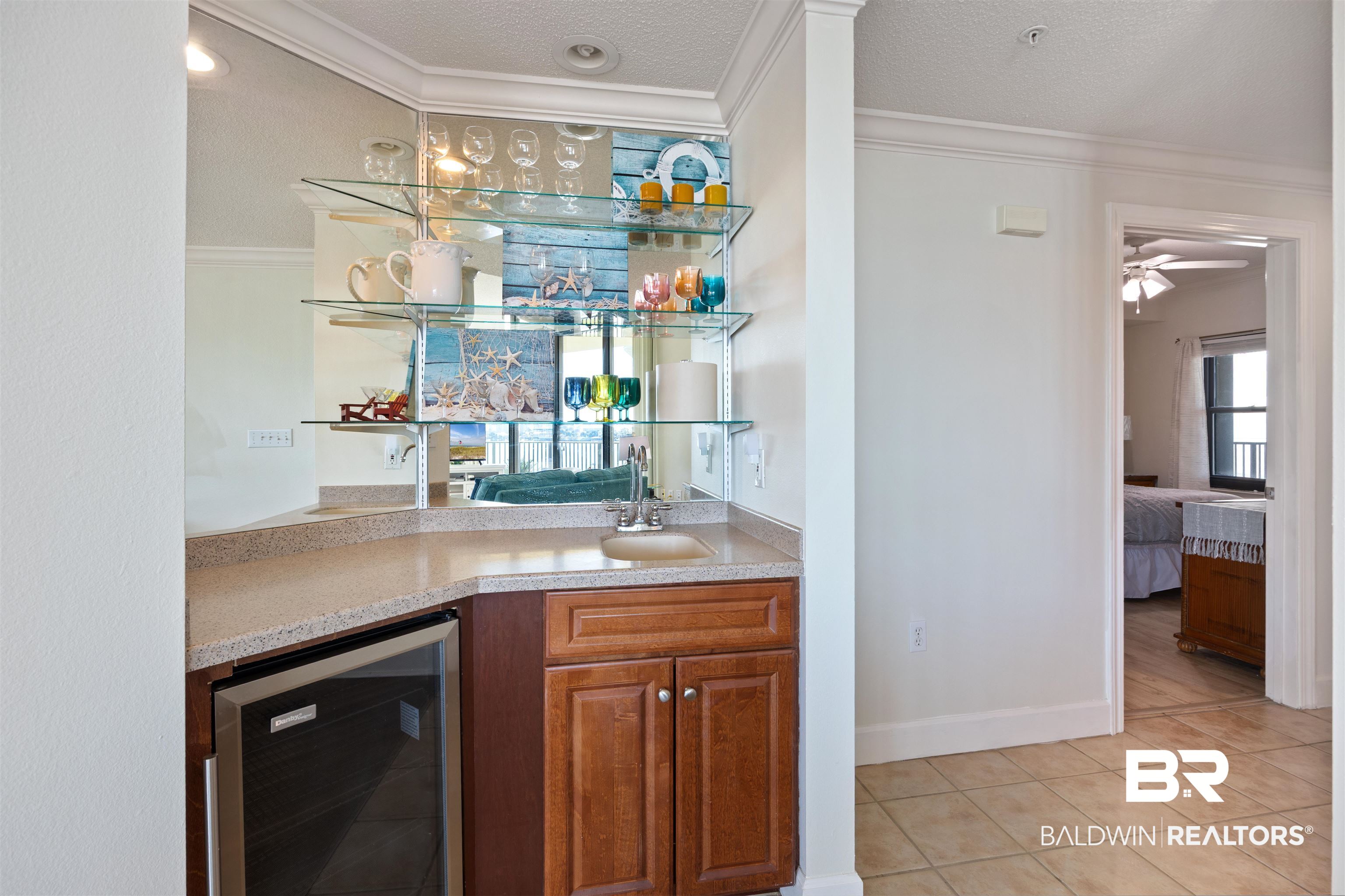 27580 Canal Road, Unit 1431 Orange Beach, AL 36561 - Photo 29 of 73 Indoor wet bar with beverage cooler, ornamental molding, a textured ceiling, brown cabinets, and light tile patterned floors
