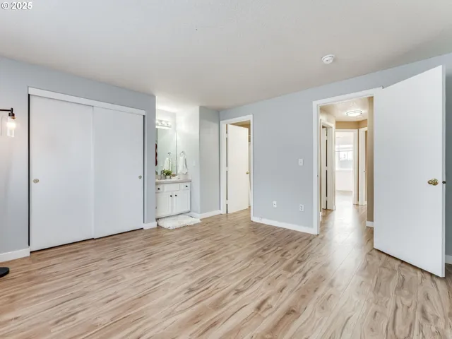 a view of a big room with wooden floor and windows