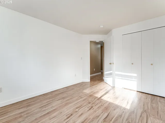 a view of an empty room with wooden floor