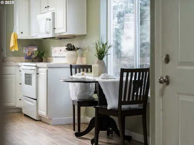 a kitchen with a table chairs refrigerator and cabinets