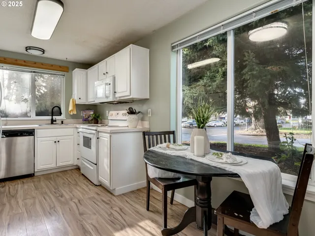 a kitchen with a table chairs a sink and cabinets