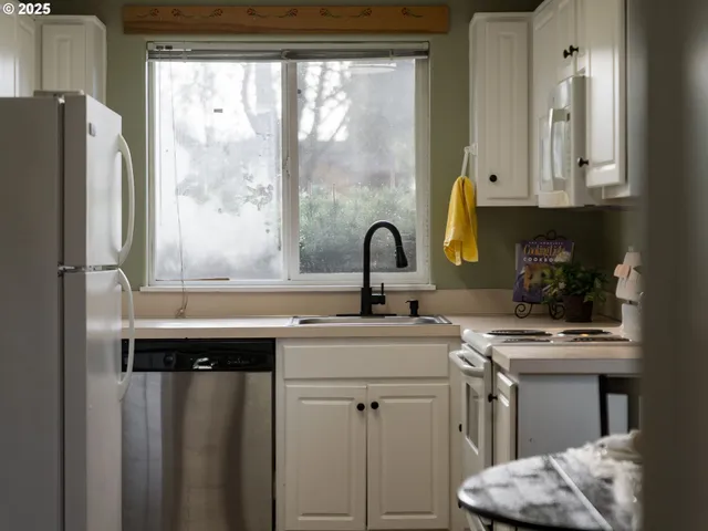 a kitchen with stainless steel appliances a sink a stove and a refrigerator