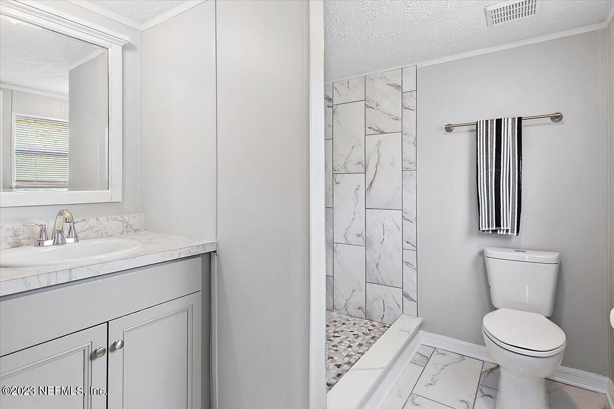 5191 County Road 23B Macclenny, FL 32063 - Photo 6 of 11 a bathroom with a granite countertop sink toilet and shower