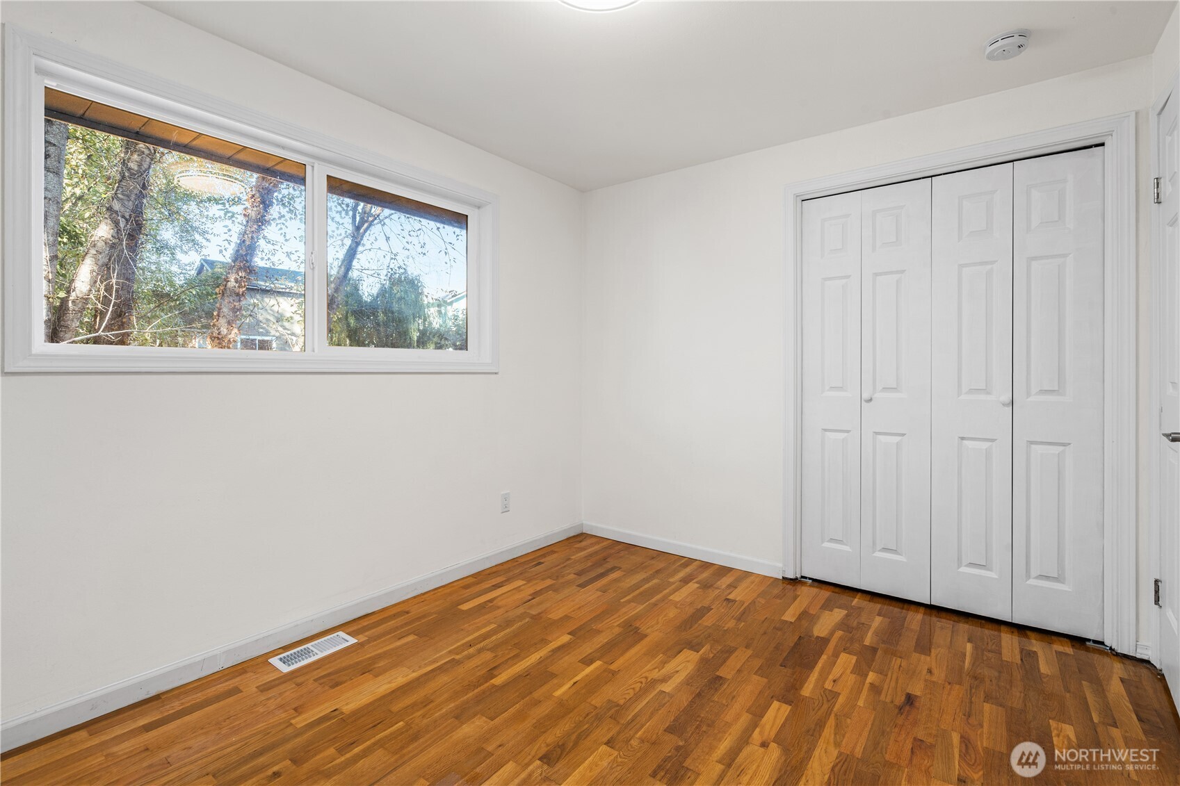 959 Hoquiam Avenue Northeast Renton, WA 98059 - Photo 15 of 30 an empty room with wooden floor and windows