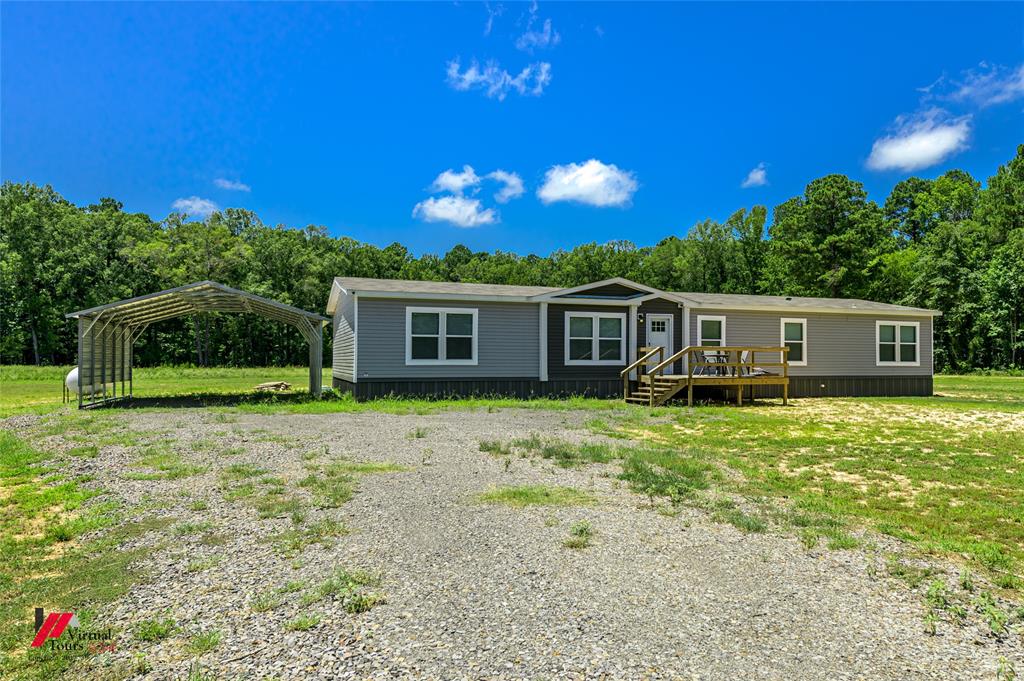 a view of a house with backyard and a tree