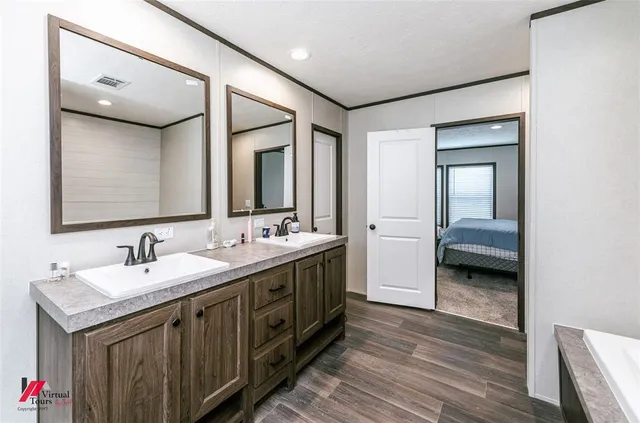a en suite bathroom with a double vanity sink and a mirror
