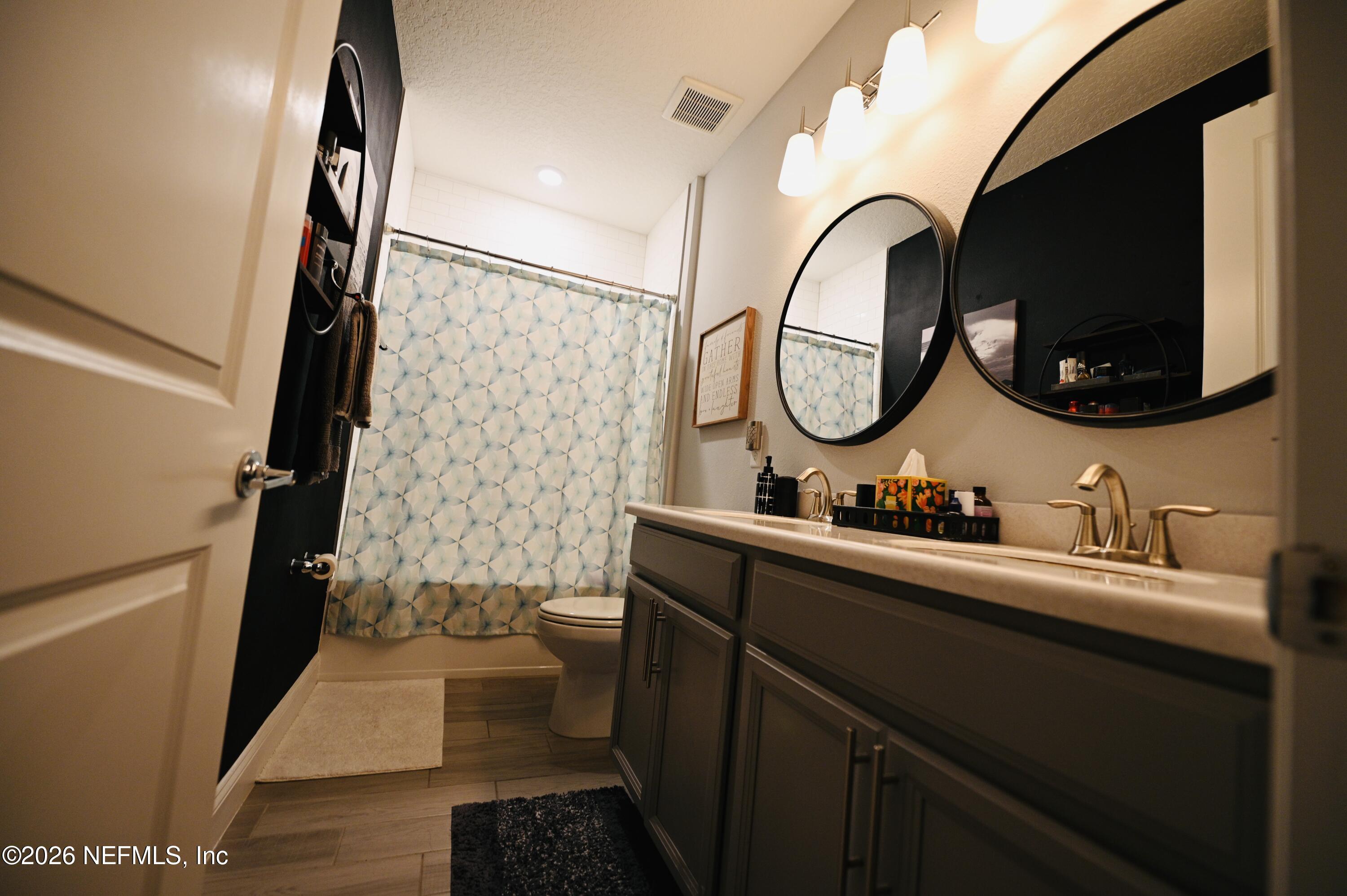 147 Clifton Bay Loop St. Johns, FL 32259 - Photo 28 of 34 a bathroom with a toilet a sink and a mirror
