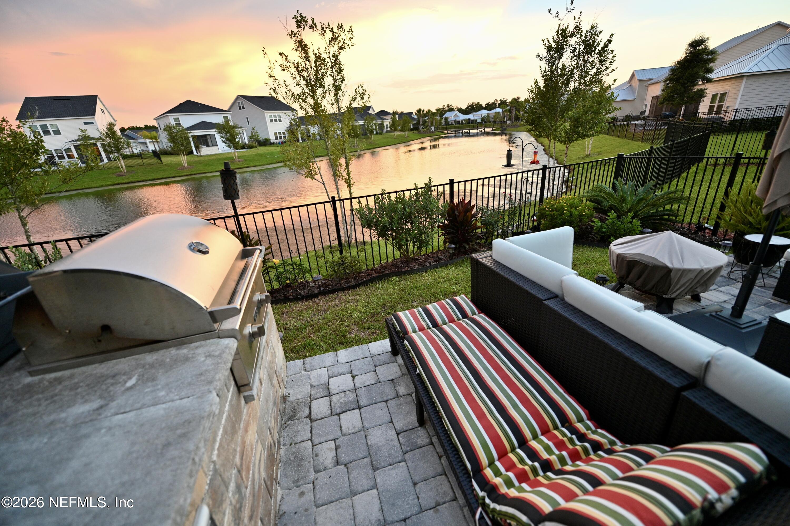 147 Clifton Bay Loop St. Johns, FL 32259 - Photo 5 of 34 a view of a lake with a bench and a floor to ceiling window