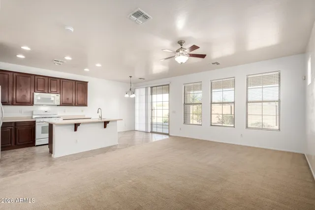 a large kitchen with stainless steel appliances kitchen island a sink a window and view living room