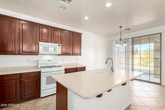 a kitchen with a sink a stove cabinets and appliances