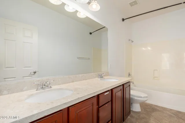 a bathroom with a granite countertop sink a toilet and a bathtub