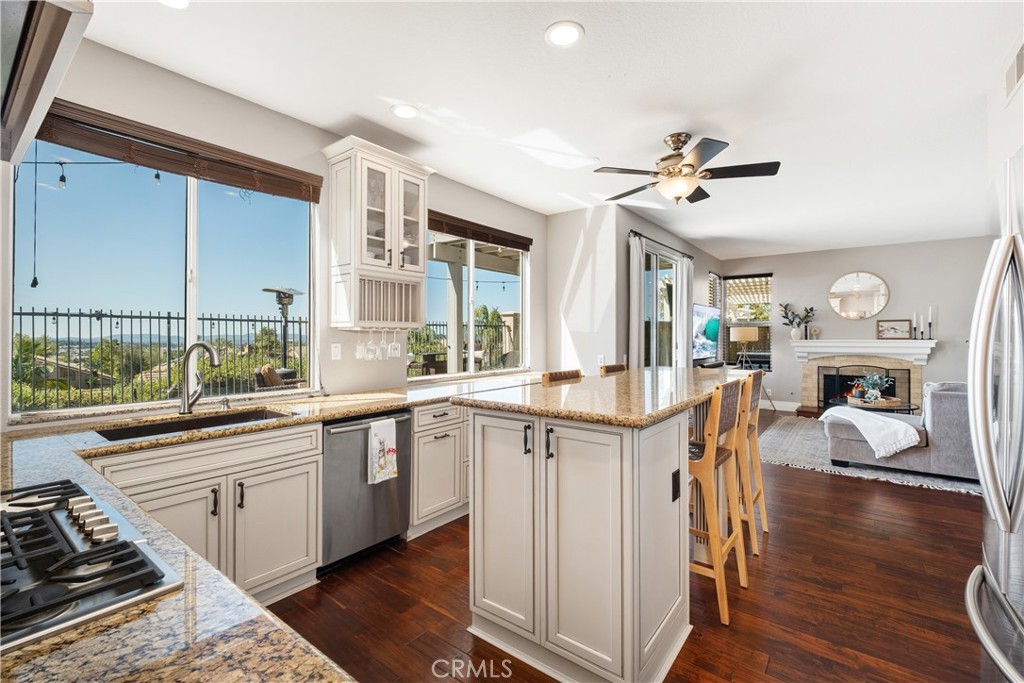22 Sierra Blanco Lake Forest, CA 92610 - Photo 13 of 47 a kitchen with stainless steel appliances granite countertop a kitchen island hardwood floor sink stove and wooden cabinets