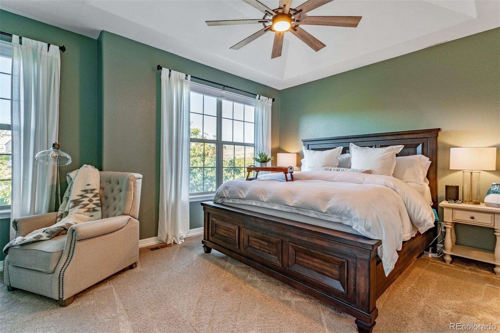 10162 RidgeGate Circle Lone Tree, CO 80124 - Photo 19 of 24 a spacious bedroom with a bed and a chandelier