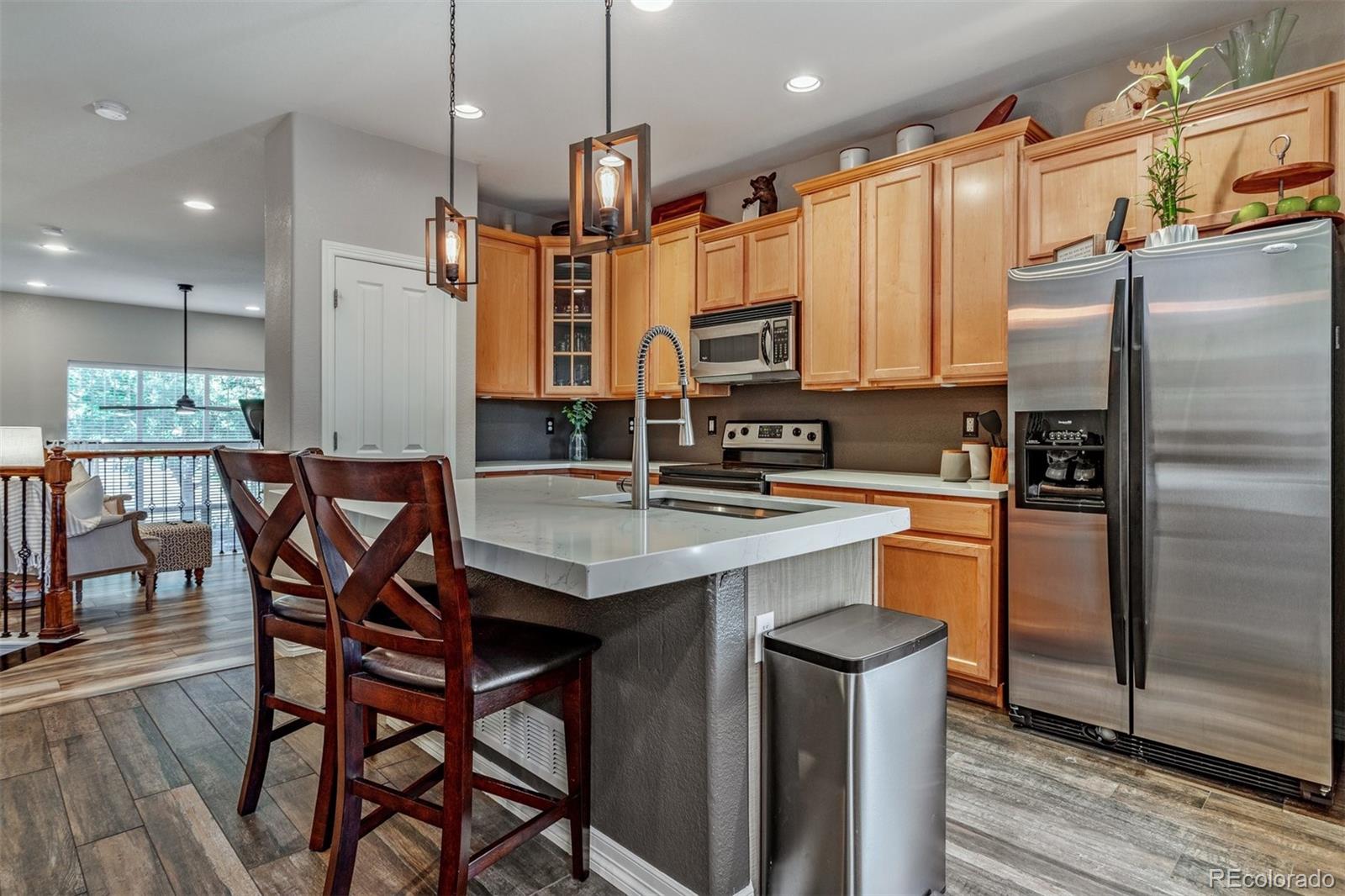 10162 RidgeGate Circle Lone Tree, CO 80124 - Photo 2 of 24 a kitchen with stainless steel appliances kitchen island granite countertop a dining table chairs and a refrigerator