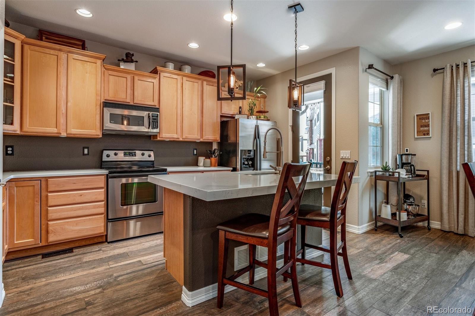 10162 RidgeGate Circle Lone Tree, CO 80124 - Photo 24 of 24 a kitchen with stainless steel appliances kitchen island granite countertop wooden cabinets a dining table and chairs