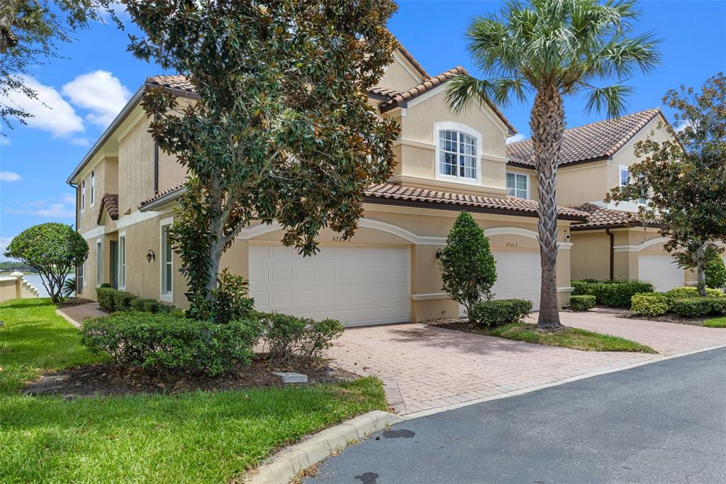 8713 The Esplanade, Unit 1 Orlando, FL 32836 - Photo 1 of 1 a front view of a house with a yard and garage