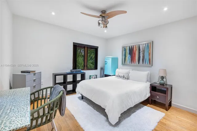 a bedroom with a bed a dresser and next to a window