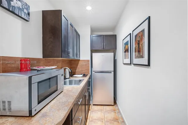 a kitchen with stainless steel appliances a refrigerator sink and microwave