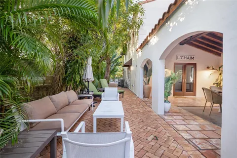 a view of a patio with couches table and chairs and potted plants