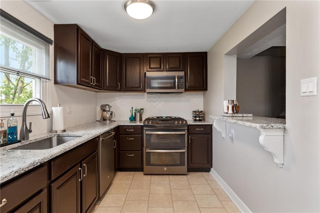 101 Unionville Road Freedom, PA 15042 - Photo 6 of 25 Totally renovated kitchen with breakfast bar, and ceramic tile flooring. The stove, microwave, dishwasher and refrigerator will be replaced with stainless steel appliances that will be installed before the settlement date.