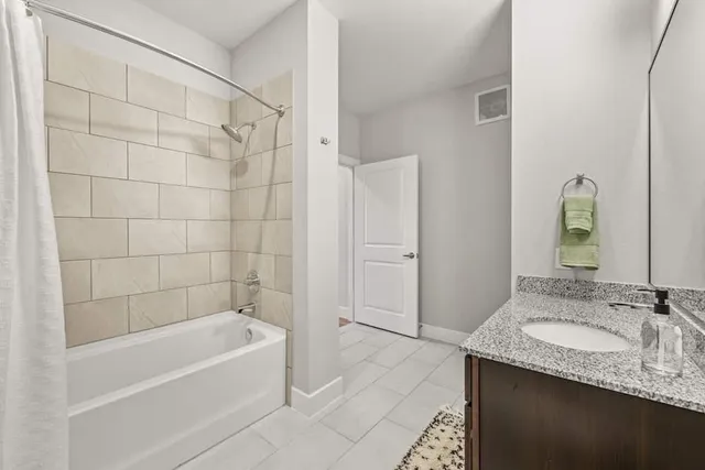 a bathroom with a granite countertop tub sink and mirror