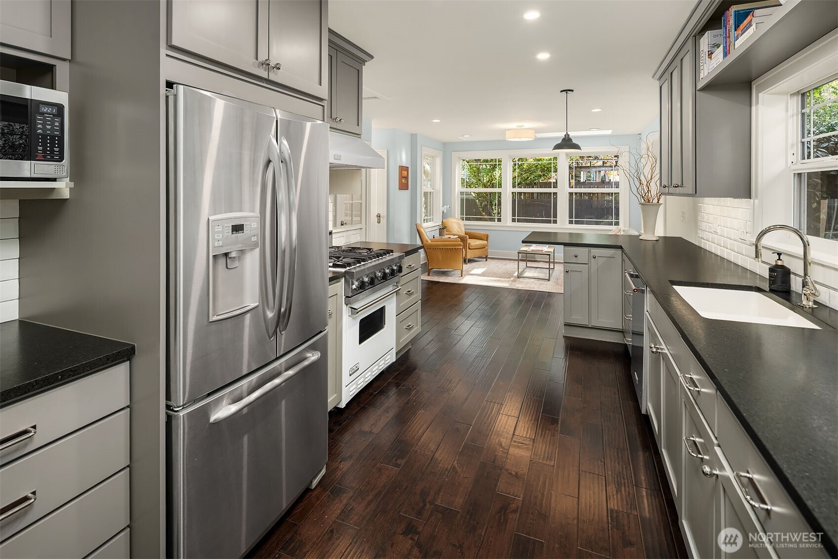 6838 30th Avenue Northeast Seattle, WA 98115 - Photo 11 of 34 a kitchen with stainless steel appliances granite countertop a refrigerator a sink dishwasher a stove and white countertops with wooden floor