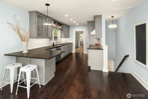 a kitchen with granite countertop a sink a counter top space and stainless steel appliances