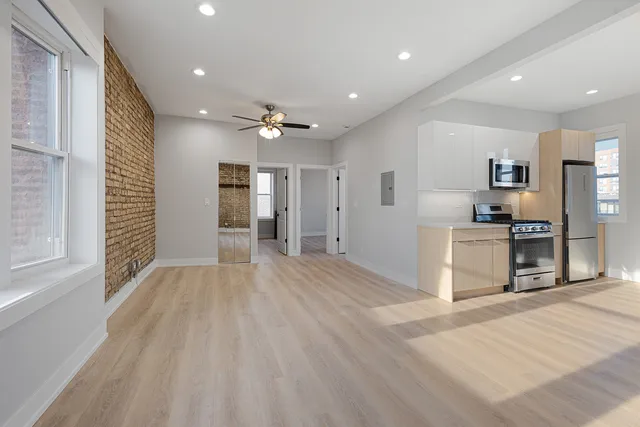 a view of a kitchen with a sink and a refrigerator