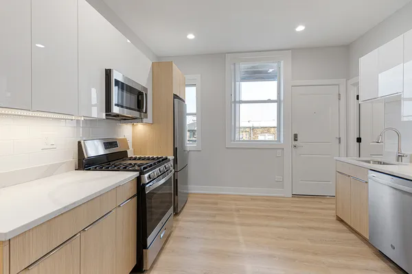 a kitchen with stainless steel appliances granite countertop a stove a sink and a microwave