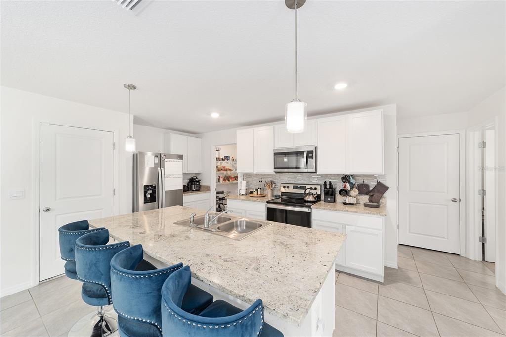8696 Southwest 46th Avenue Ocala, FL 34476 - Photo 17 of 51 a kitchen with stainless steel appliances kitchen island granite countertop a sink and cabinets