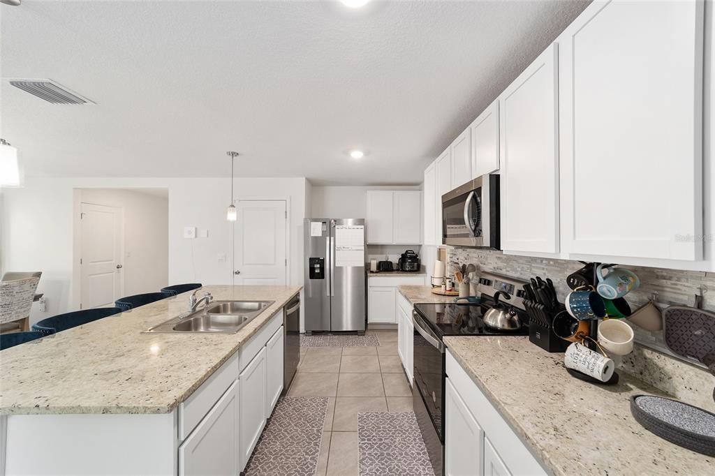 8696 Southwest 46th Avenue Ocala, FL 34476 - Photo 18 of 51 a kitchen with stainless steel appliances granite countertop a sink stove and refrigerator