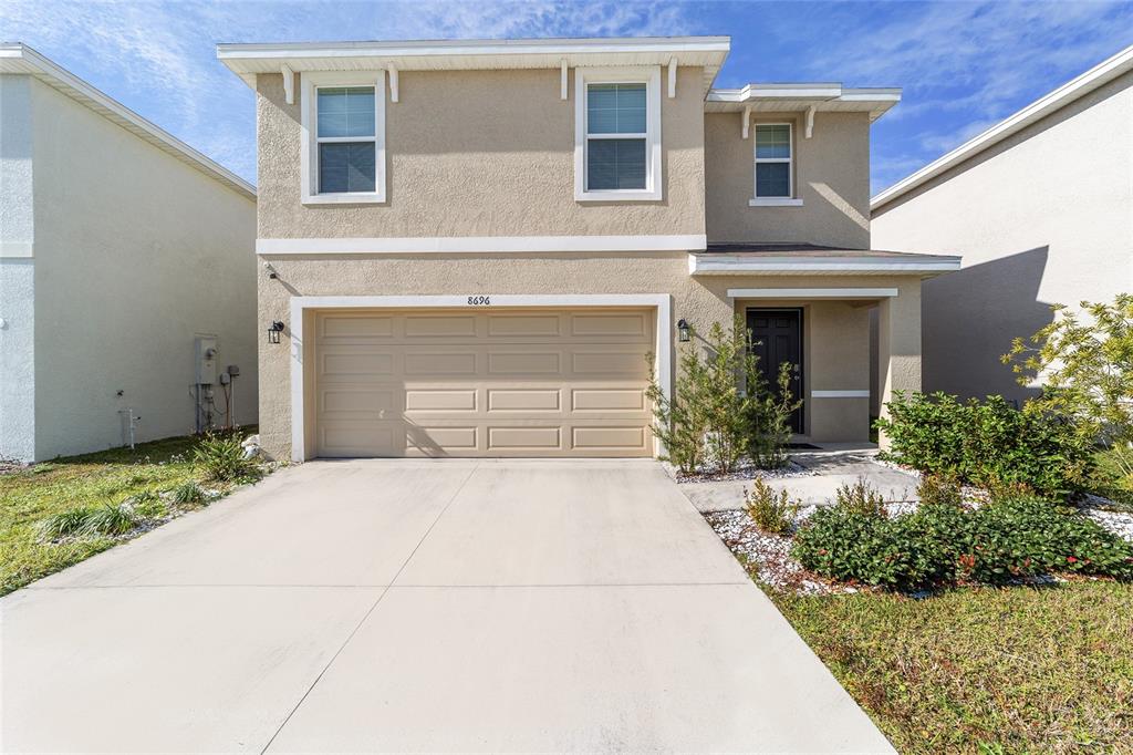 8696 Southwest 46th Avenue Ocala, FL 34476 - Photo 2 of 51 a front view of a house with a yard and garage