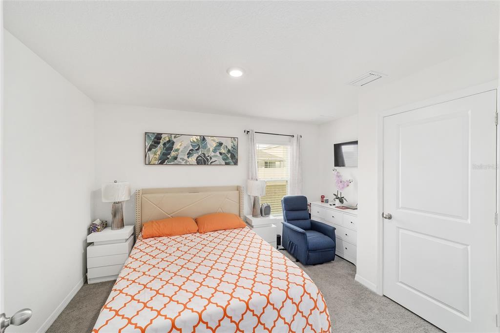 8696 Southwest 46th Avenue Ocala, FL 34476 - Photo 21 of 51 a bedroom with a large bed and a lamp