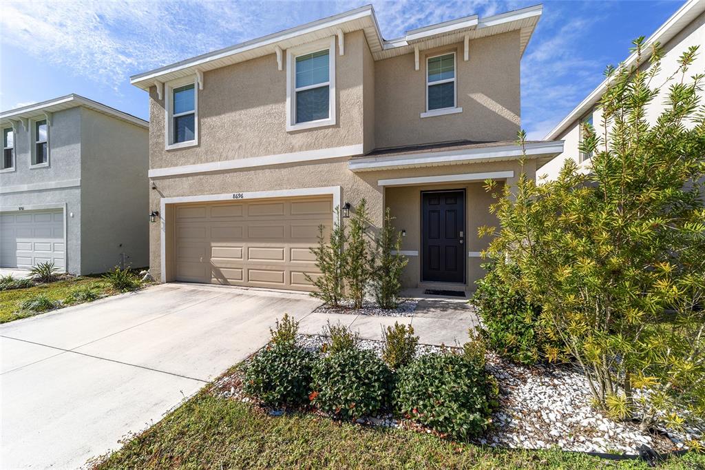 8696 Southwest 46th Avenue Ocala, FL 34476 - Photo 3 of 51 a front view of a house with a yard and garage