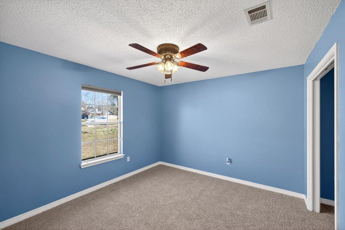 608 Northview Drive Crestview, FL 32536 - Photo 29 of 39 an empty room with windows and a chandelier fan