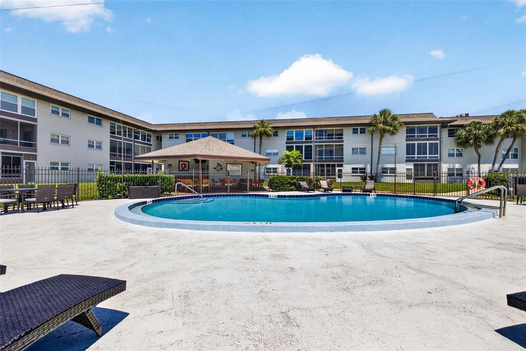 5197 Silent Loop, Unit 124 New Port Richey, FL 34652 - Photo 43 of 55 a view of a big building with swimming pool and sitting area