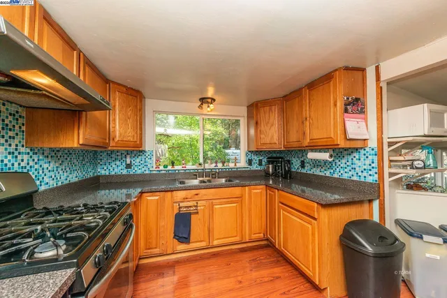 a kitchen with stainless steel appliances granite countertop a stove a sink and a refrigerator