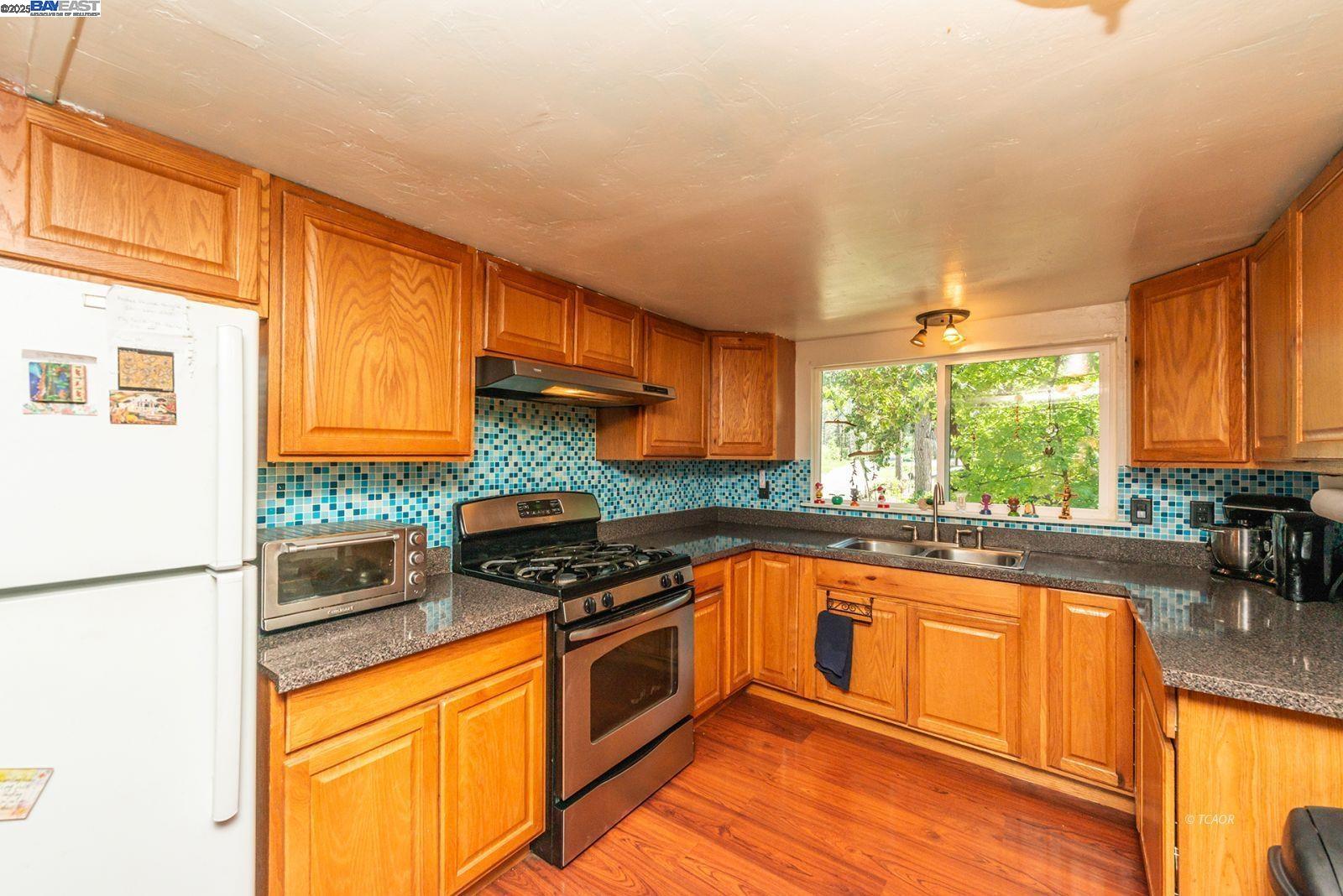 2940 Dutch Creek Road Junction City, CA 96048 - Photo 15 of 47 a kitchen with stainless steel appliances granite countertop a stove a sink and a refrigerator