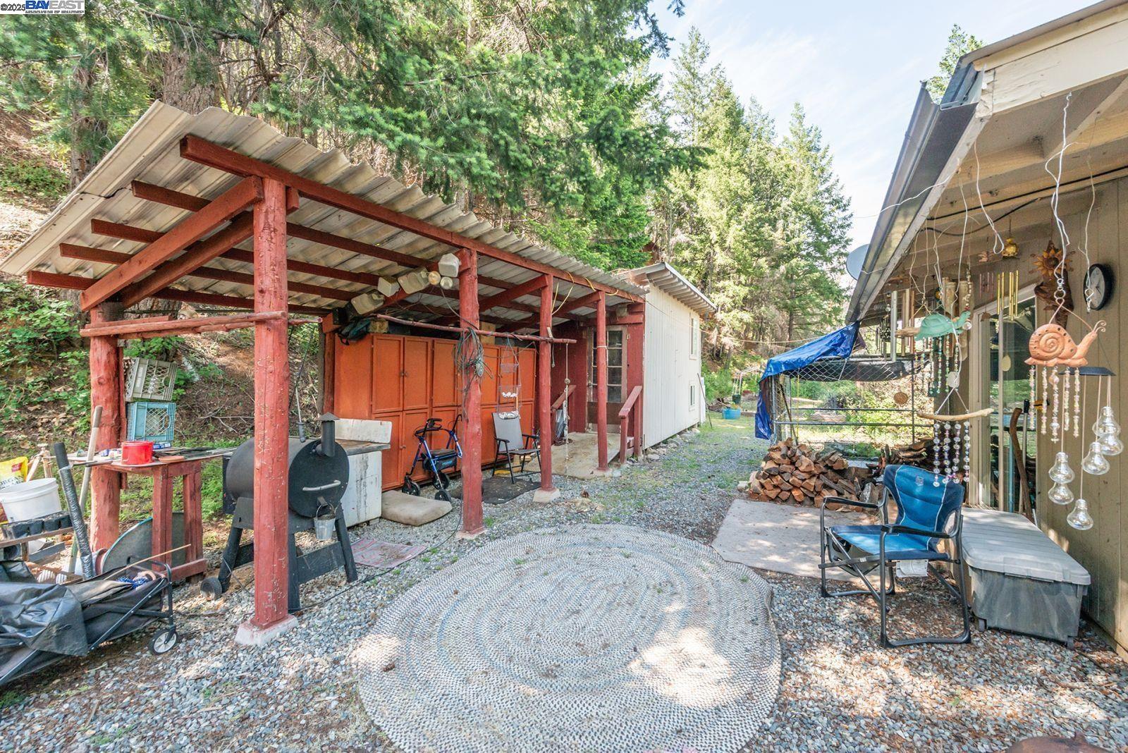 2940 Dutch Creek Road Junction City, CA 96048 - Photo 27 of 47 a view of a patio with table and chairs potted plants and large tree