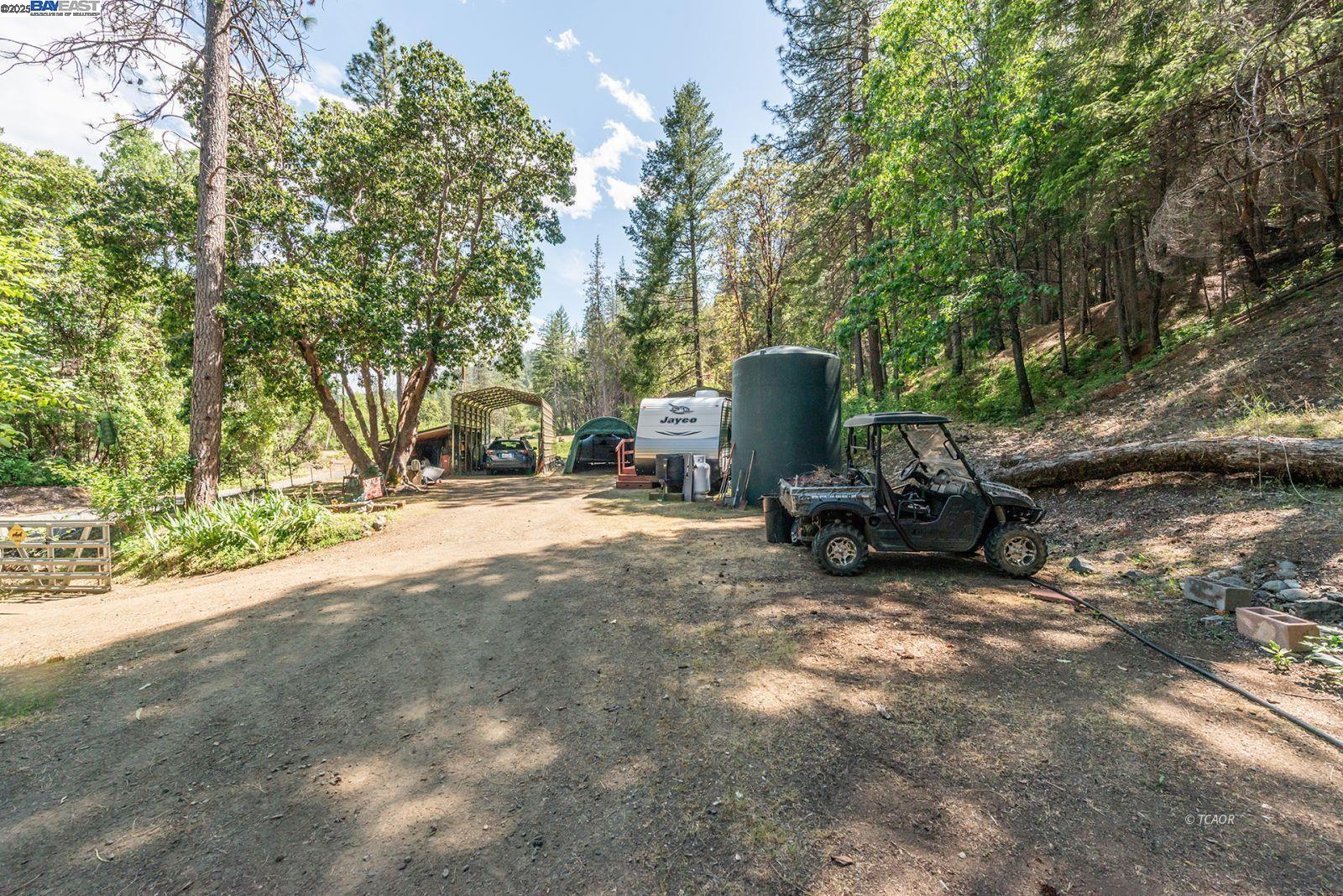 2940 Dutch Creek Road Junction City, CA 96048 - Photo 29 of 47 a view of backyard with a table and chairs and a large tree