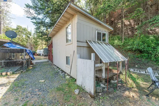 a view of backyard with wooden fence and a bench