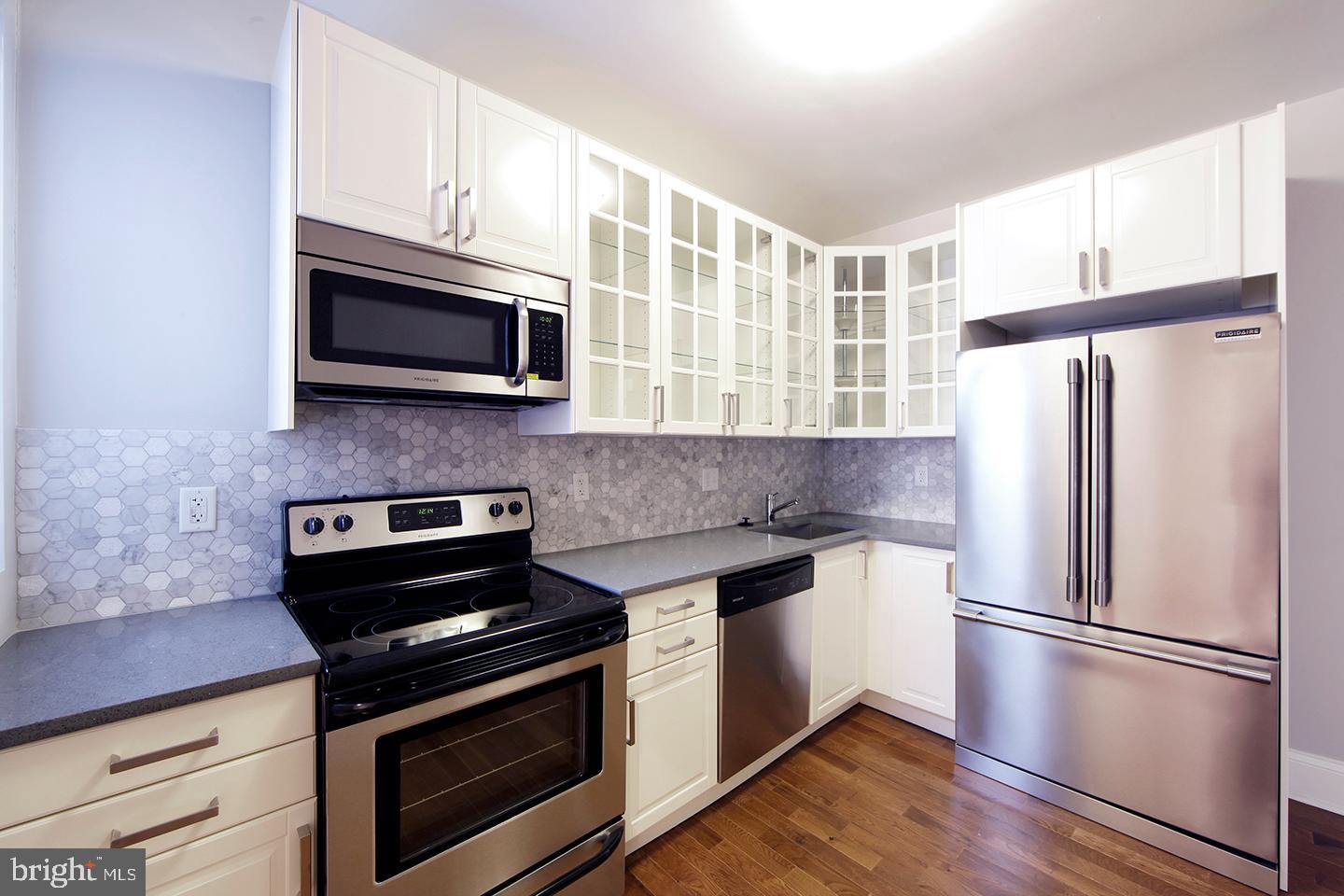 a kitchen with stainless steel appliances a refrigerator microwave and stove top oven