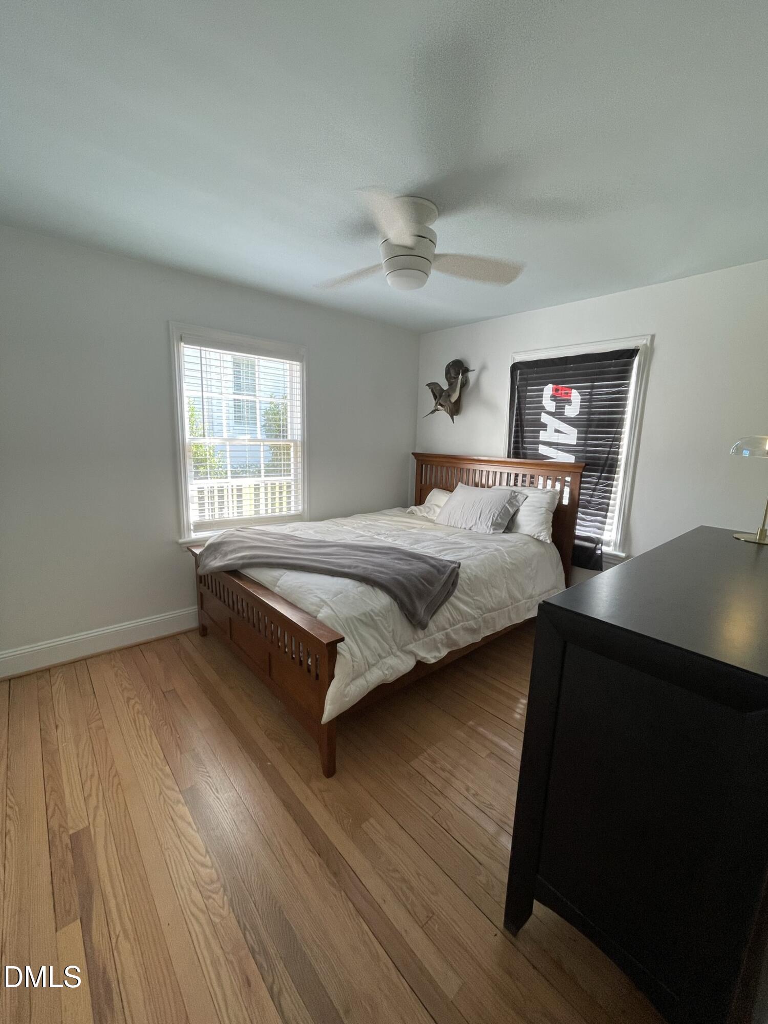 1009 Canterbury Road Raleigh, NC 27607 - Photo 8 of 31 a bedroom with a bed and wooden floor