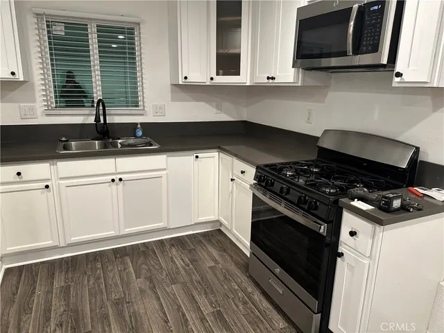 a kitchen with granite countertop a stove and a sink